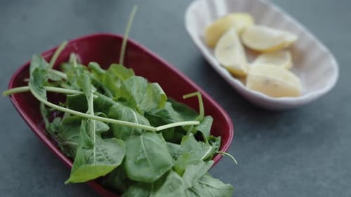 Fresh Green Arugula Leaves in a Red Heartshaped Bowl