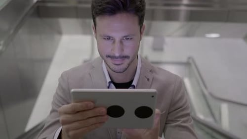 Man Uses Tablet on Escalator