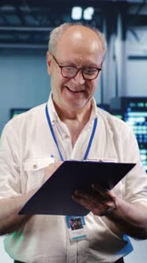 Man Holding Clipboard in Dark Server Room