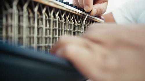 Hands Repairing an Accordion with Screwdriver