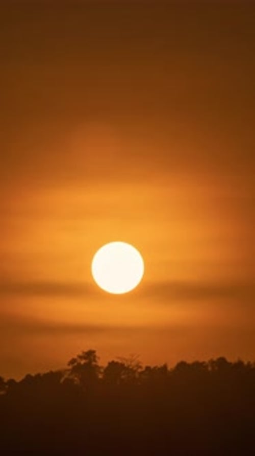 Timelapse of dramatic sunrise with orange sky in a sunny day.