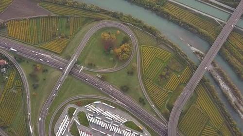 Top Down Aerial View of Highway Interstate Road with Fast Moving Traffic and Parking Lot with Parked
