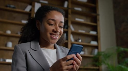 Businesswoman Typing Message on Smartphone Indoors