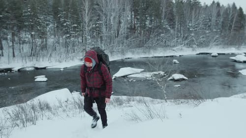 Backpacker Walking Up the Hill during Winter Hike