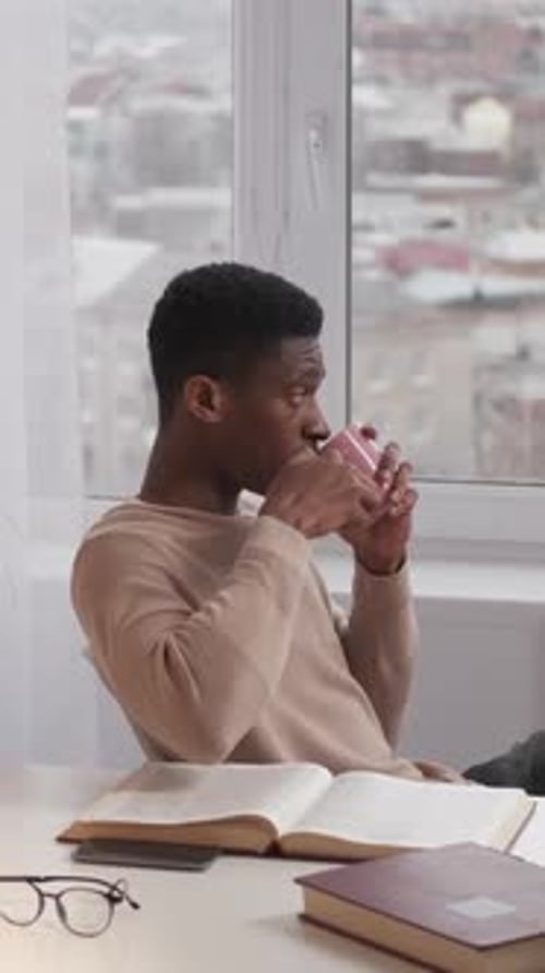 Young Adult Drinking Tea by Window