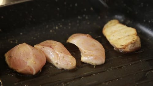 Chicken Breast with Herbs Being Fried on a Pan