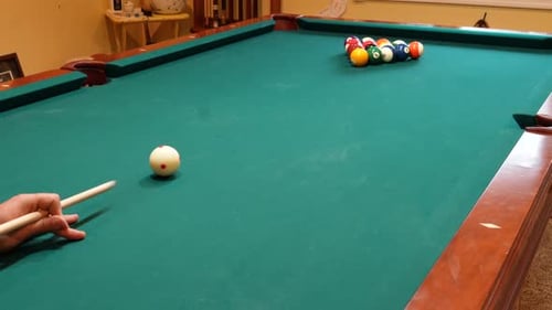 Person Breaks Pool Balls on 8 Ball Triangle Rack on the Spot with Solid and Stripped Billiard Balls