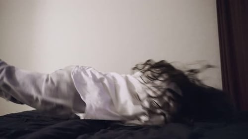 Exhausted Young Woman Falling Down on Bed While Feeling Tired