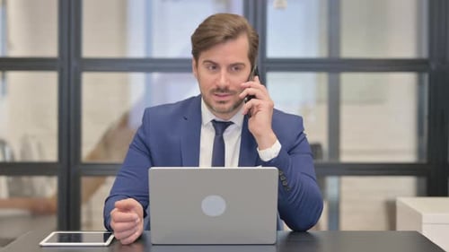Man in Blue Suit Talking on Cell Phone