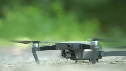 Drone Copter with Blurred Propellers and Video Camera Flying in Air