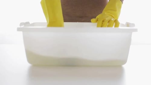 Woman Cleaning with Sponge and Yellow Rubber Gloves