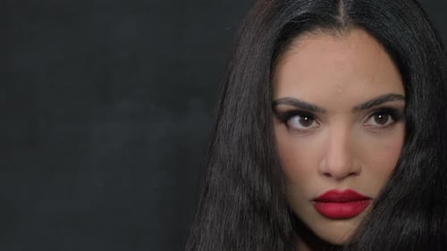 Elegant Woman with Red Lipstick Looks at Camera