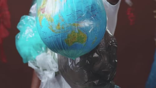 Person with Trash Bags and Globe Environmental Awareness