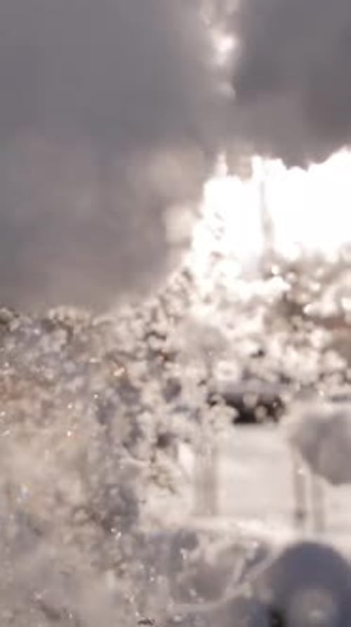 Vertical of Snow Flakes Falling From a Tree Branch