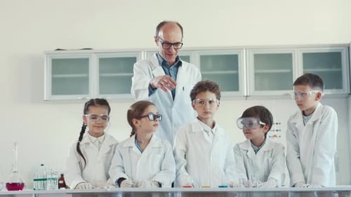 Enthusiastic Children Learning Science With Teacher In Lab