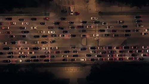 Aerial Drone View in Motion at Night Flying Along an Road with Rush Hour Traffic Top Down View