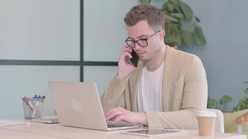 Young Adult Man Multitasking in Office