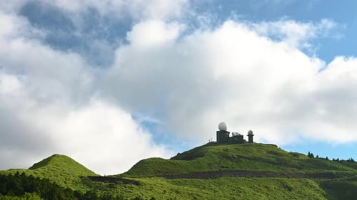 Heavenly Views: Mountain Peak's Clear Blue Sky and Moving White Clouds.