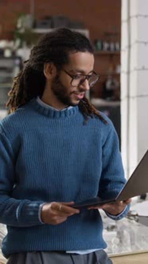 Vertical of Biracial Male Engineer Standing with Laptop in Modern Office