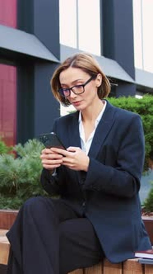 Business Woman Using Smartphone Outdoors Standing on City Street Looking to Mobile Phone Screen