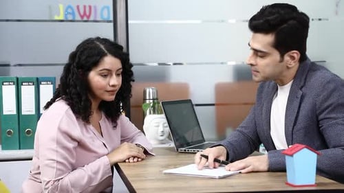 Video of woman signing an agreement and shaking hand with real estate agent on a meeting