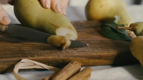 a pear is cut on a wooden board, still life, there are other details to decorate the scene such as o