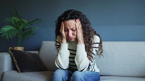 Woman is Distressed and Lies Down on Couch