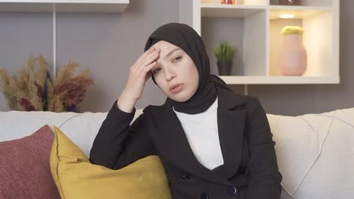 Woman with Headache Seated Indoors