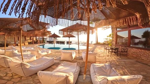 Pool by the beach at sunset with reflection of palm trees, tropical landscape, exotic island hotel o