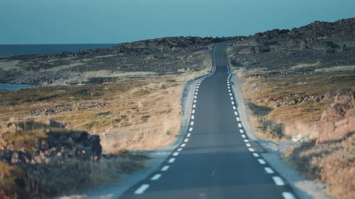 Driving on the narrow road along the Varanger coastline. Dashcam view, slow pan forward.