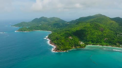 Litoral turquesa com colinas verdes que se estendem até o oceano Seychelles Mahe