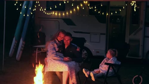 The Family is Sitting Together in the Evening By the Campfire Enjoying the Warmth Family Vacation