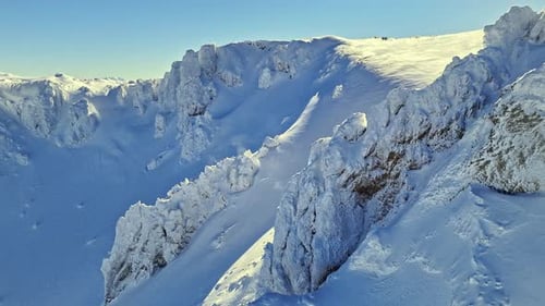 Schneebedeckter Bergrücken unter klarem blauem Himmel