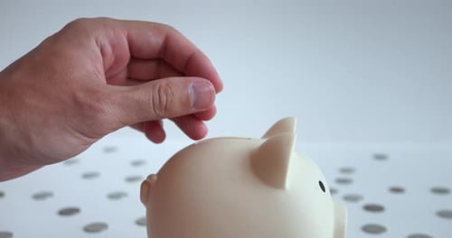 Closeup Hand Confidently Throwing Coin Into Pigshaped Piggy Bank Coin Glistens in Sun Giving Scene