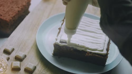 Frosting being applied to square cake at home