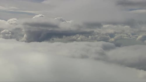 Luftaufnahme zwischen weißen, flauschigen Wolken mit Wolken oben und unten