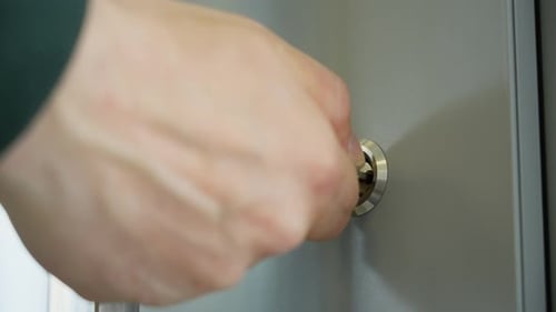 A Man's Hand Inserts the Key Into the Lock Turns It and Opens the Door