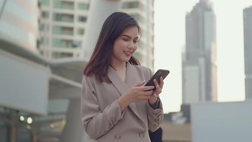 A young beautiful businesswoman is using Smart phone in Modern city