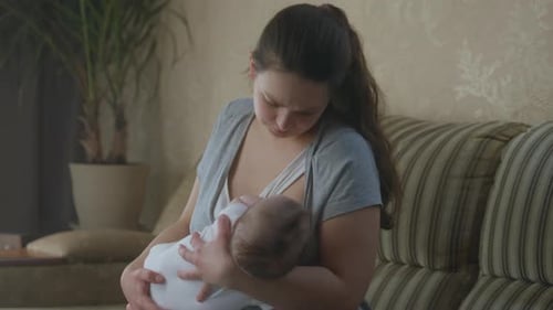 Mother Nursing Baby in Cozy Home Interior
