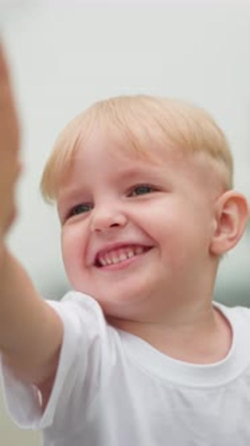 Niño feliz chocando los cinco mientras interactúa juguetonamente con una mujer