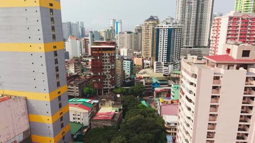 Vol lent d'un Drone entre des gratte-ciel colorés à Binondo, Manille