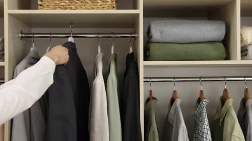 Arranging Clothing in Modern Closet, Organizing Wardrobe at Home