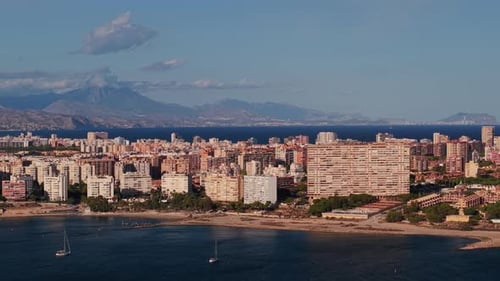 Panoramic View of Alicante City with Residential Buildings Coastline and Distant Mountains Under a