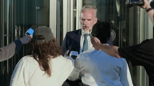 Man in Suit Speaking to Reporters Outside