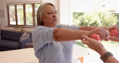 Senior Woman Exercising Arms with Dumbbells at Home