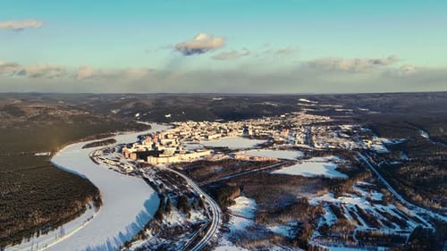 Aerial Winter Cityscape with Frozen River and Forest