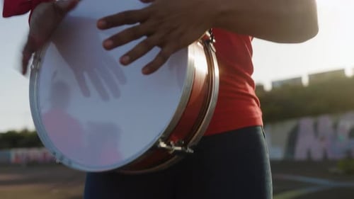 Red sport football fan celebrating playing drums at stadium tribune