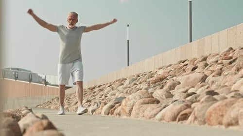 Senior Man Stretching Arms in Urban Park