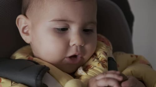 Baby Sits with Walnut in the Hands
