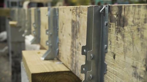 Soporte de acero sobre el alféizar de madera para el marco de una casa, de cerca en el sitio de construcción